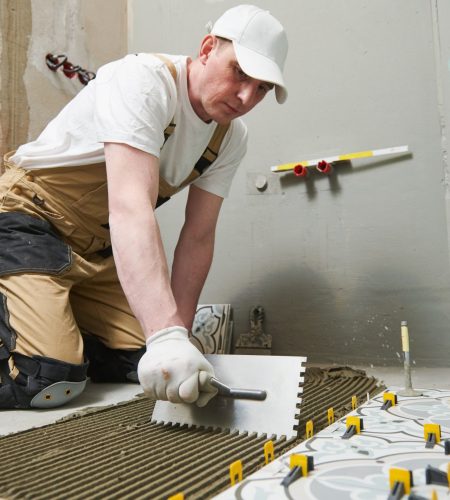 Tiler installing decoration ceramic tile on floor in bathroom. home indoors renovation